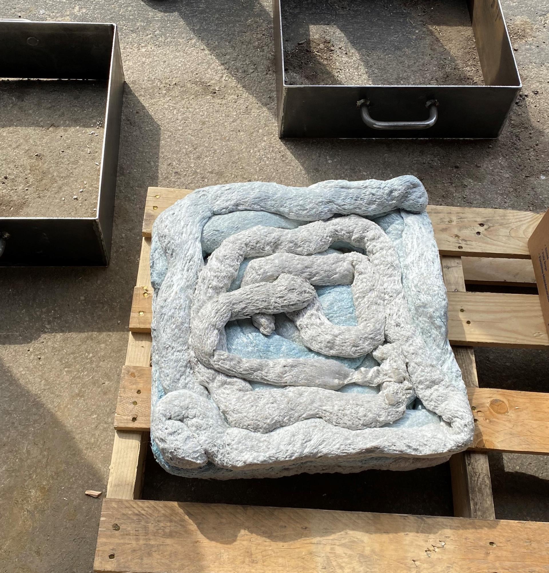A large concrete block resting on a wooden pallet